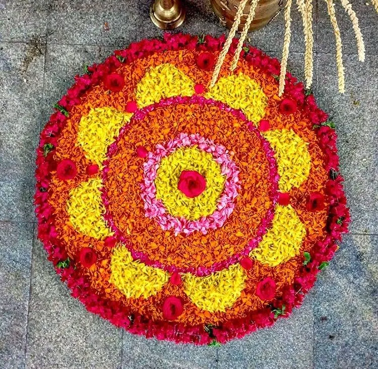 Circular Pookalam with Red and Yellow floral layers image