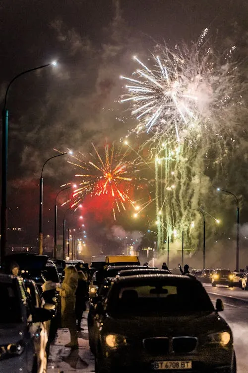 City Fireworks Display over Cars at Night with Bright HD