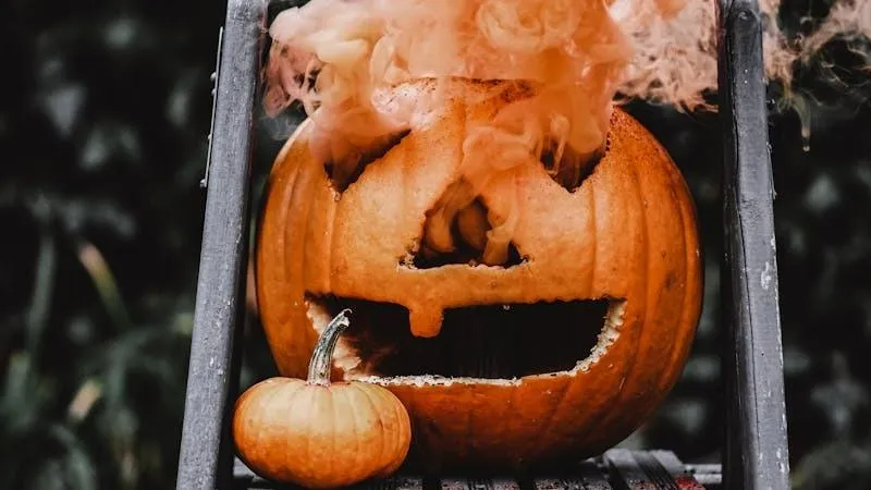 Classic Jack O Lantern Pumpkin on Fence with Orange Smoke