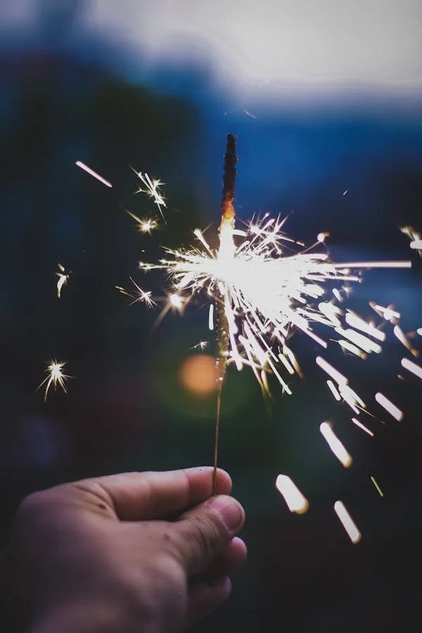 Close up of Sparkler in Hand Creating Glowing Lights in Dark