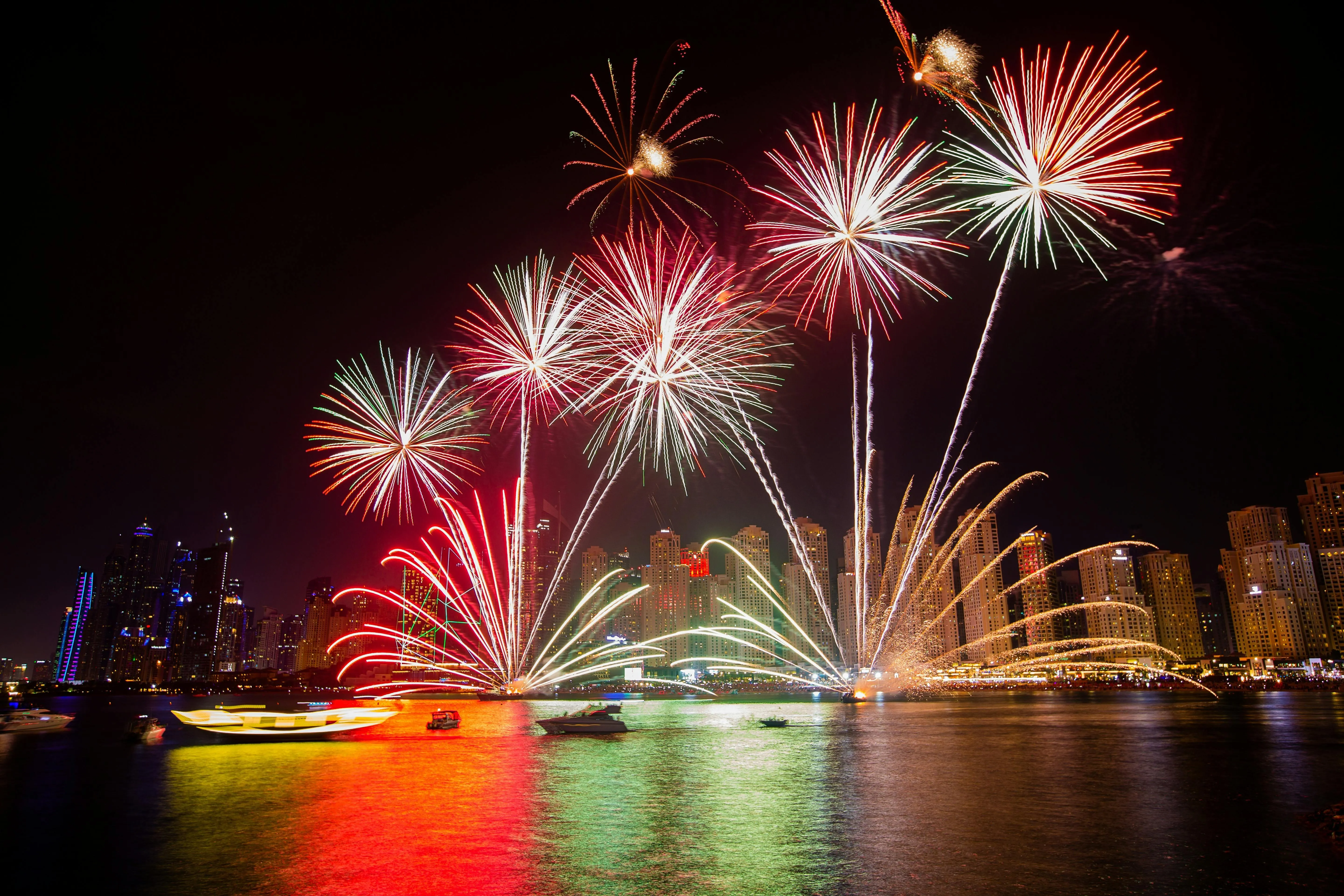 Colorful fireworks exploding over a city skyline at night
