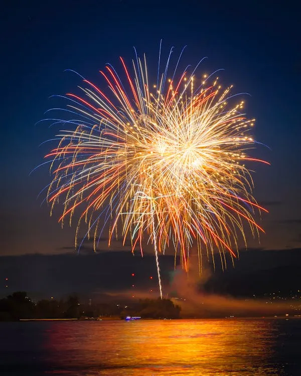 Colorful fireworks exploding over the lake reflecting the beauty
