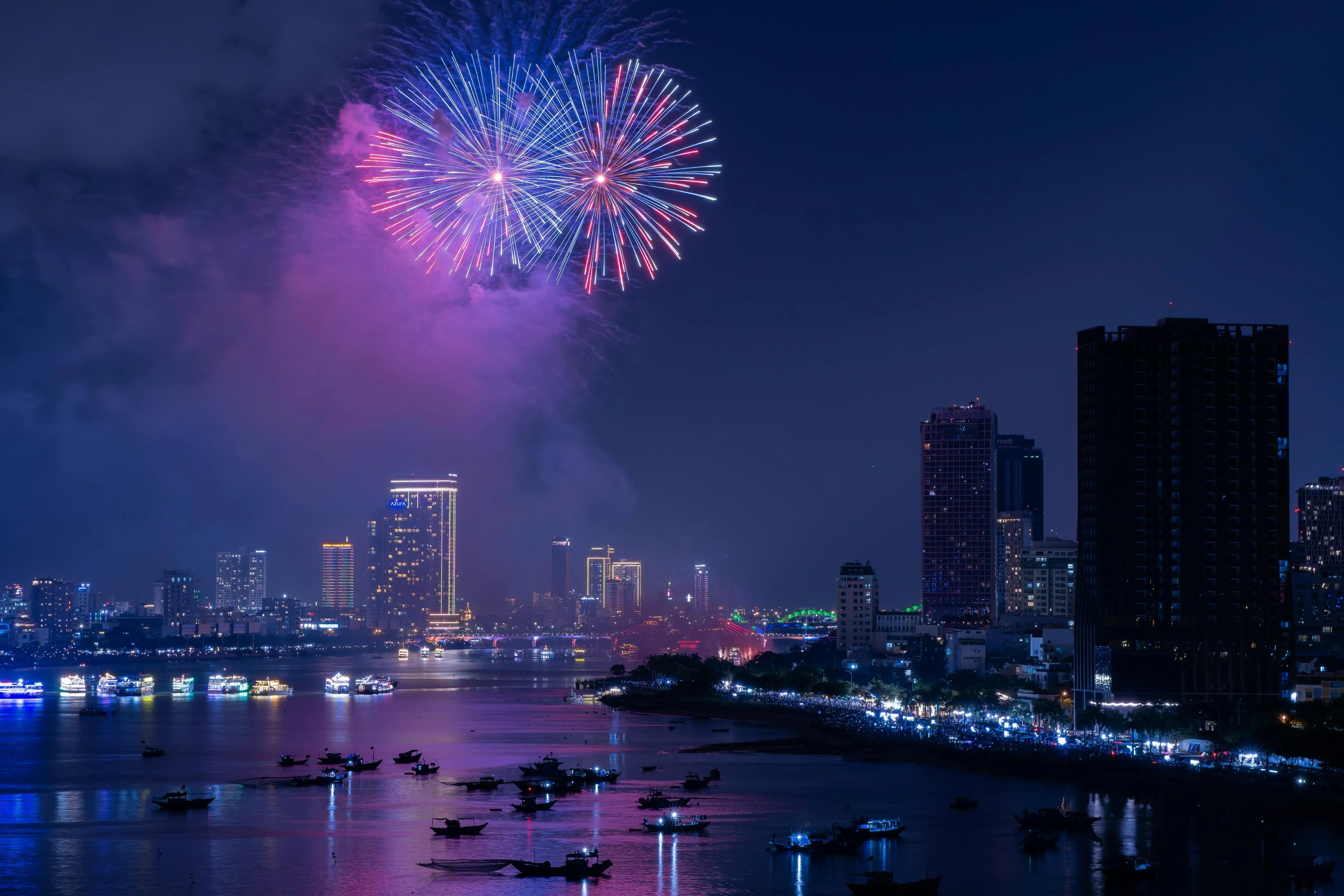 Colorful fireworks light up the sky over the cityscape 4k