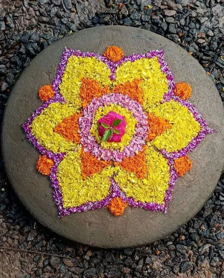 Colourful Onam Pookolam on stone base with petal art PNG