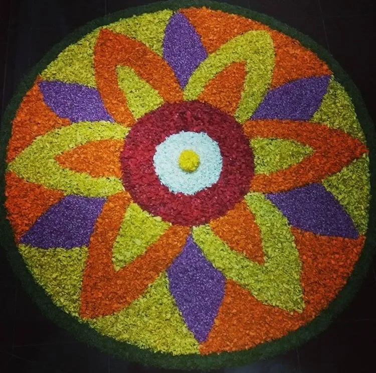 Colourful petal shaped floral rangoli for Onam Decoration