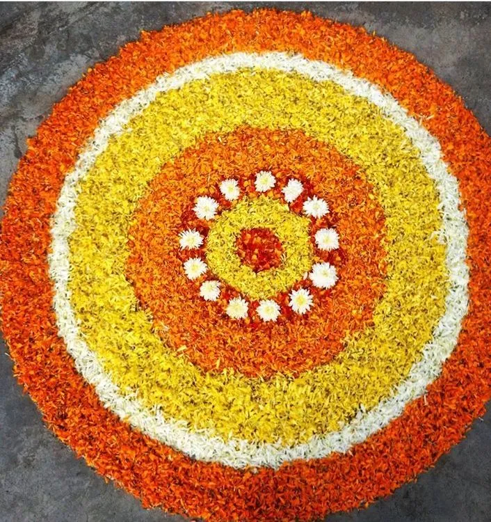 Concentric circle pookolam with yellow and orange petals