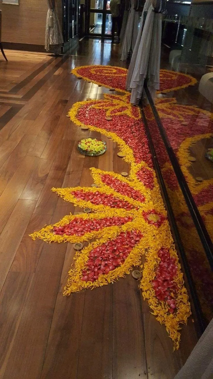 Corner floral art kolam with orange and pink flower petals