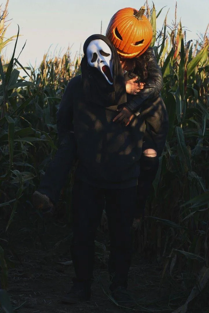 Couple Dressed in Halloween Costumes Embracing in Cornfield