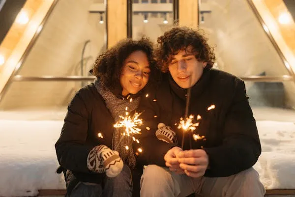 Couple Enjoying Sparkler Moments in Cozy Setting Wallpaper