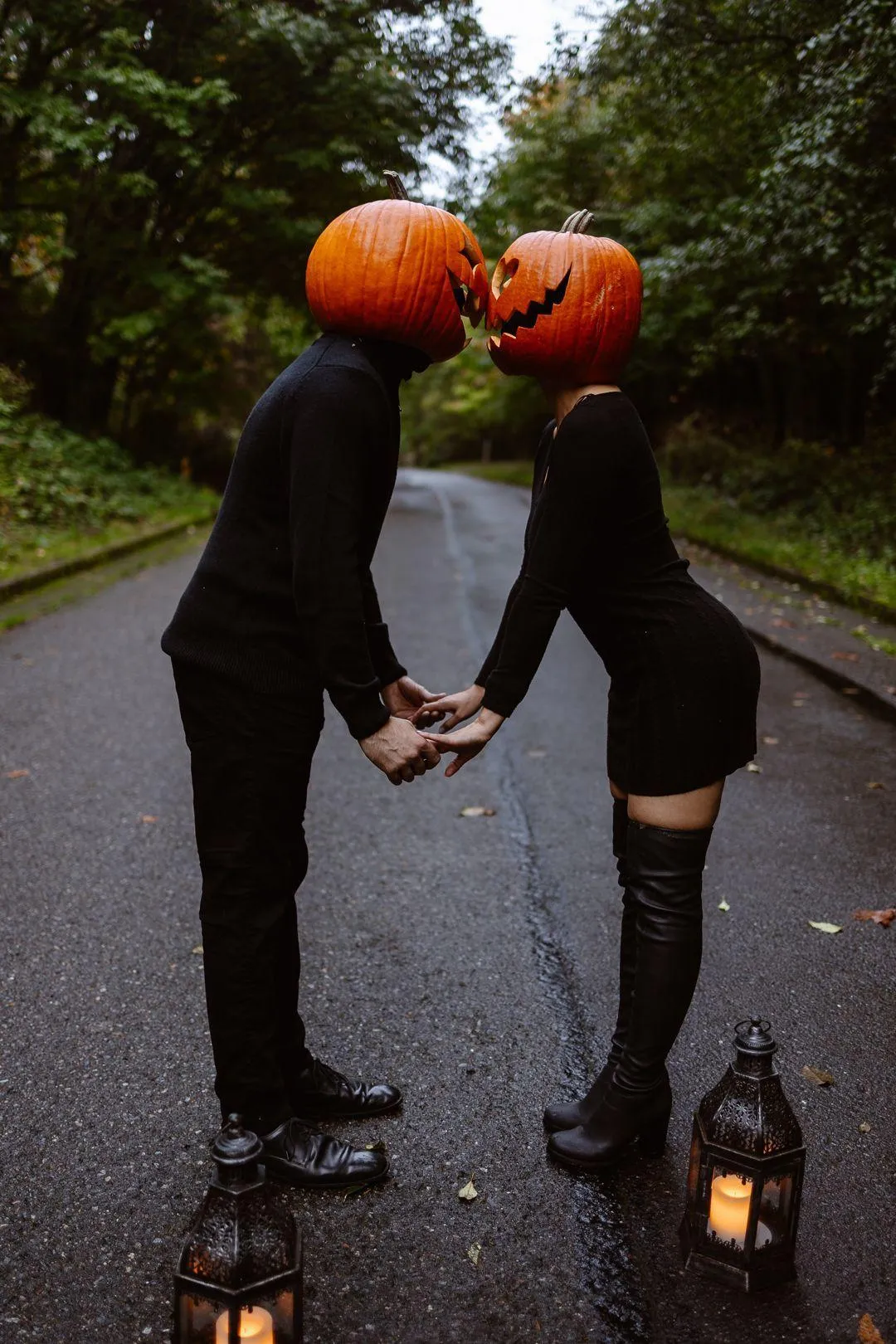 Couple Holding Hands Wearing Pumpkin Masks on Autumn Path