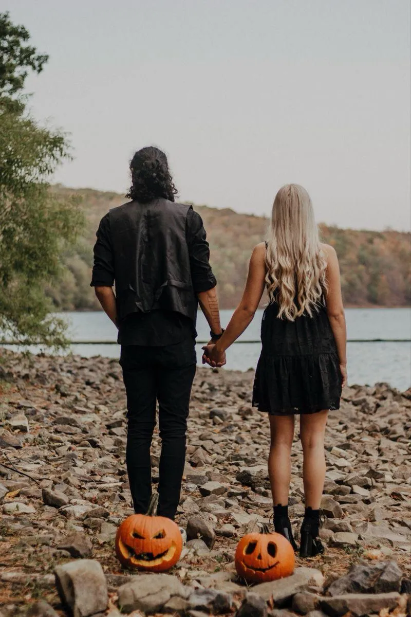 Couple Holding Hands with Pumpkin at Lakeside Halloween