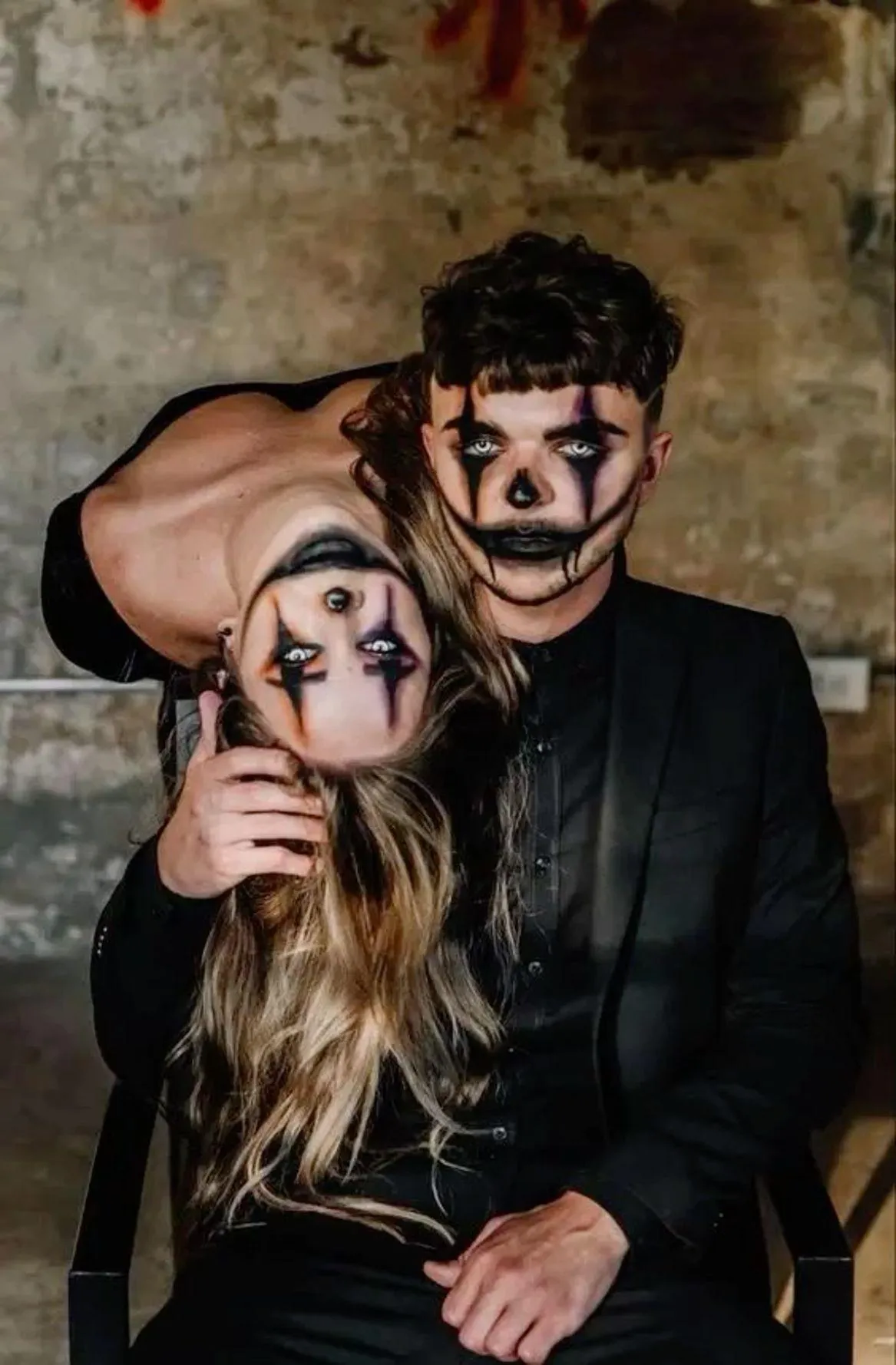 Couple in Dark Halloween Makeup Posing Indoors Wallpaper
