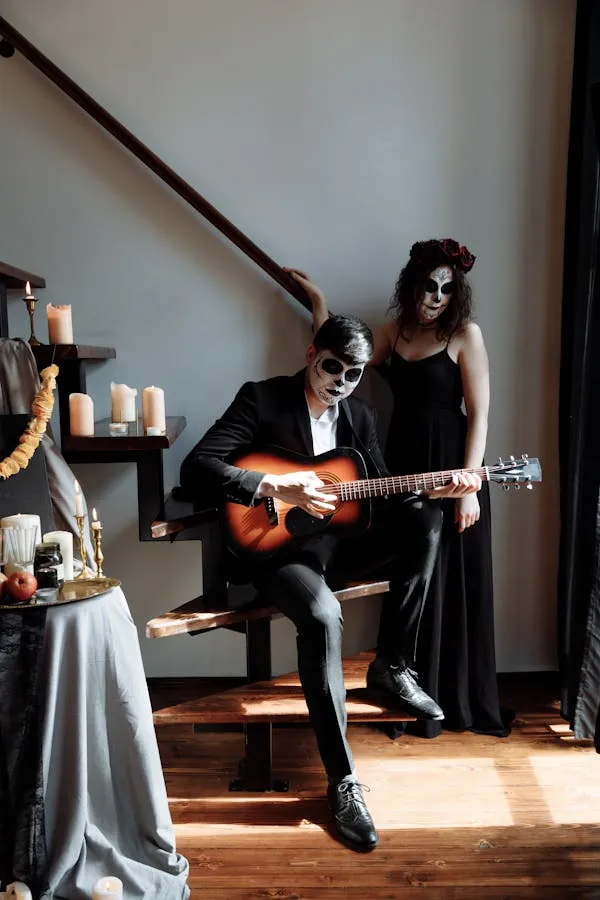 Couple in Day of the Dead costumes with guitar and candles