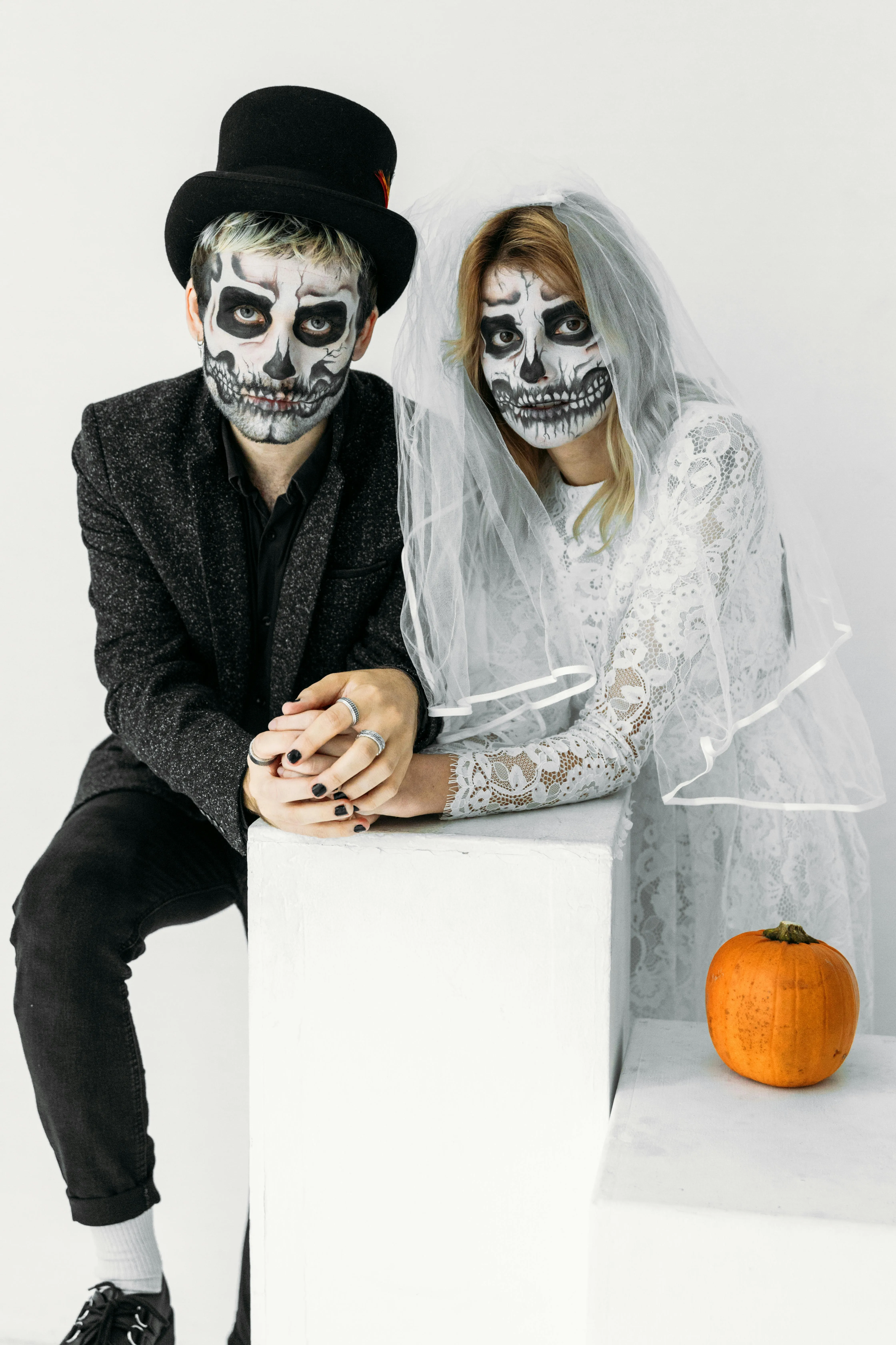 Couple in Day of the Dead Makeup Sitting with Pumpkins