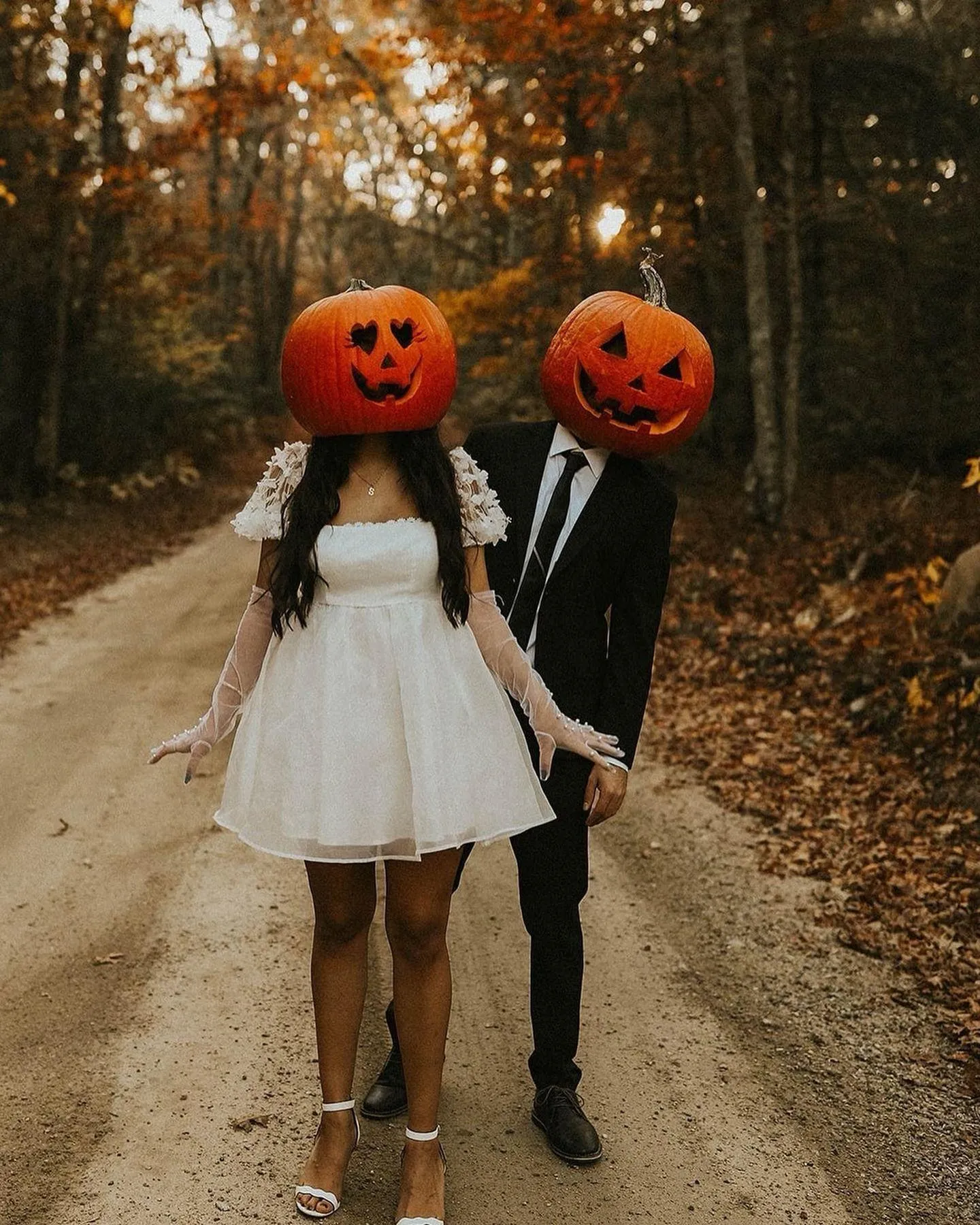Couple in Pumpkin Heads Walking Hand in Hand on Dirt Path