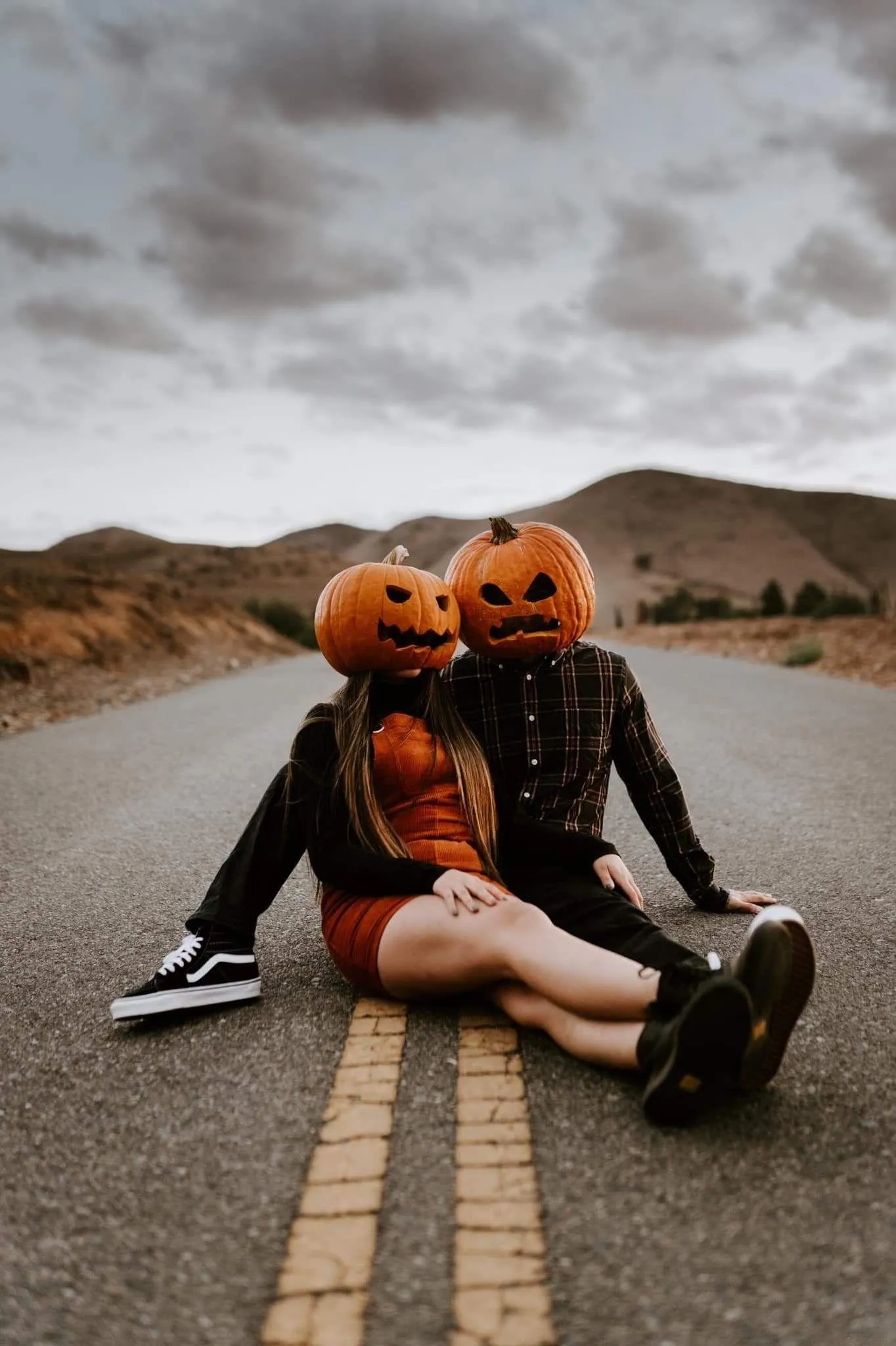 Couple Wearing Pumpkin Head Costumes on road way image