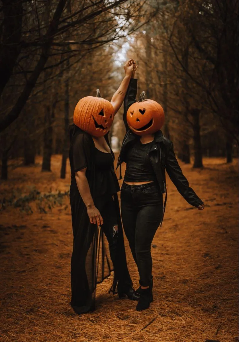 Couple Wearing Pumpkin Heads Dancing in the densr forest
