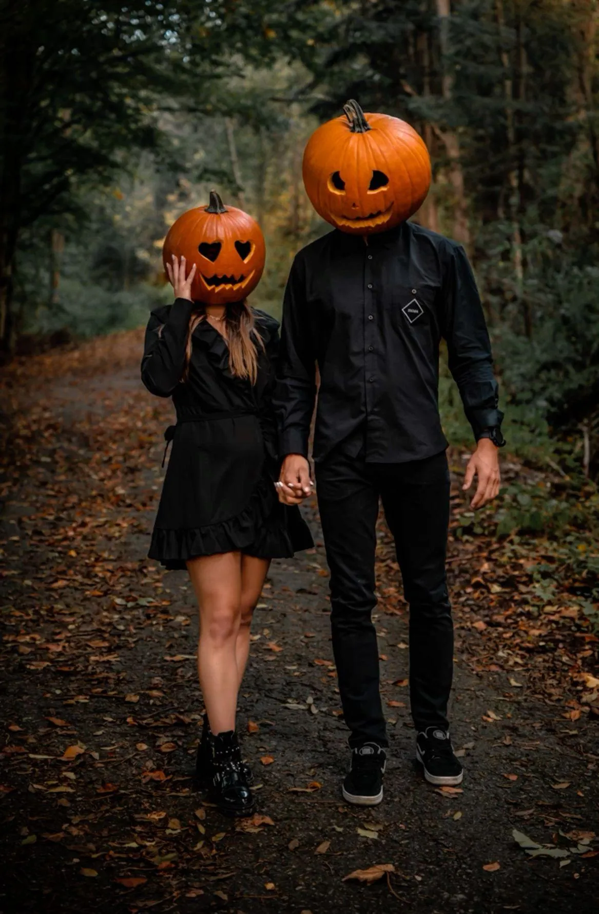 Couple Wearing Pumpkin Heads in a Forest Path Wallpaper