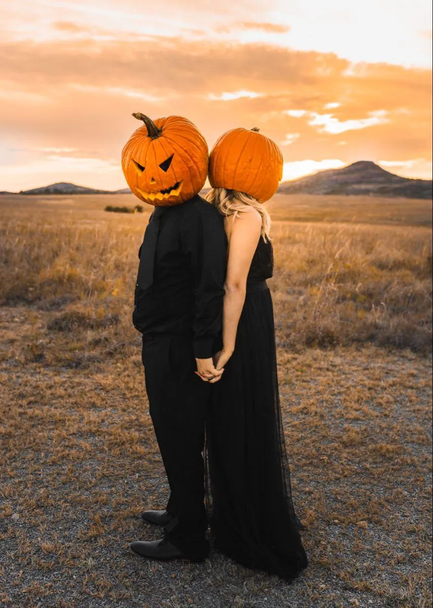Couple Wearing Pumpkin Heads Standing Back to Back image