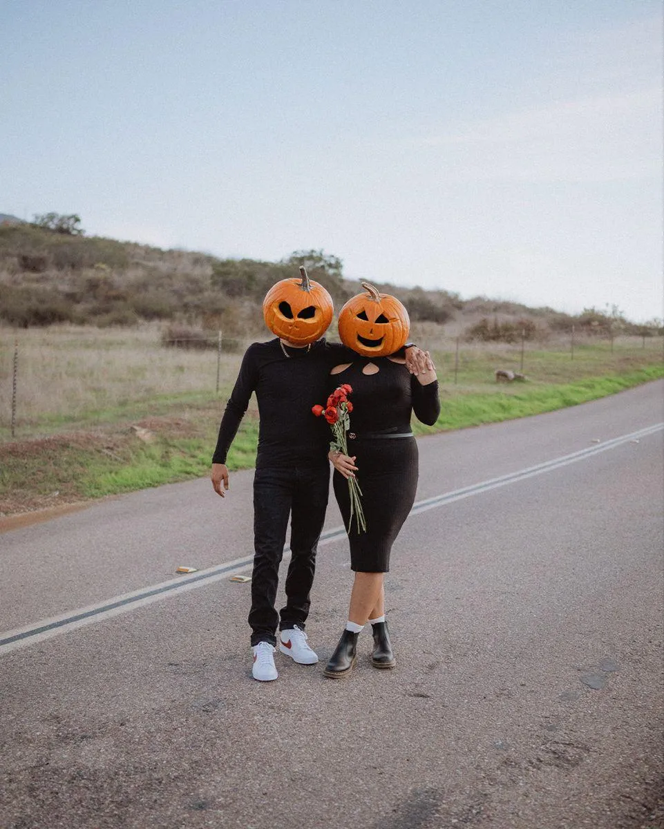 Couple Wearing Pumpkin Heads Walking on Road HD image
