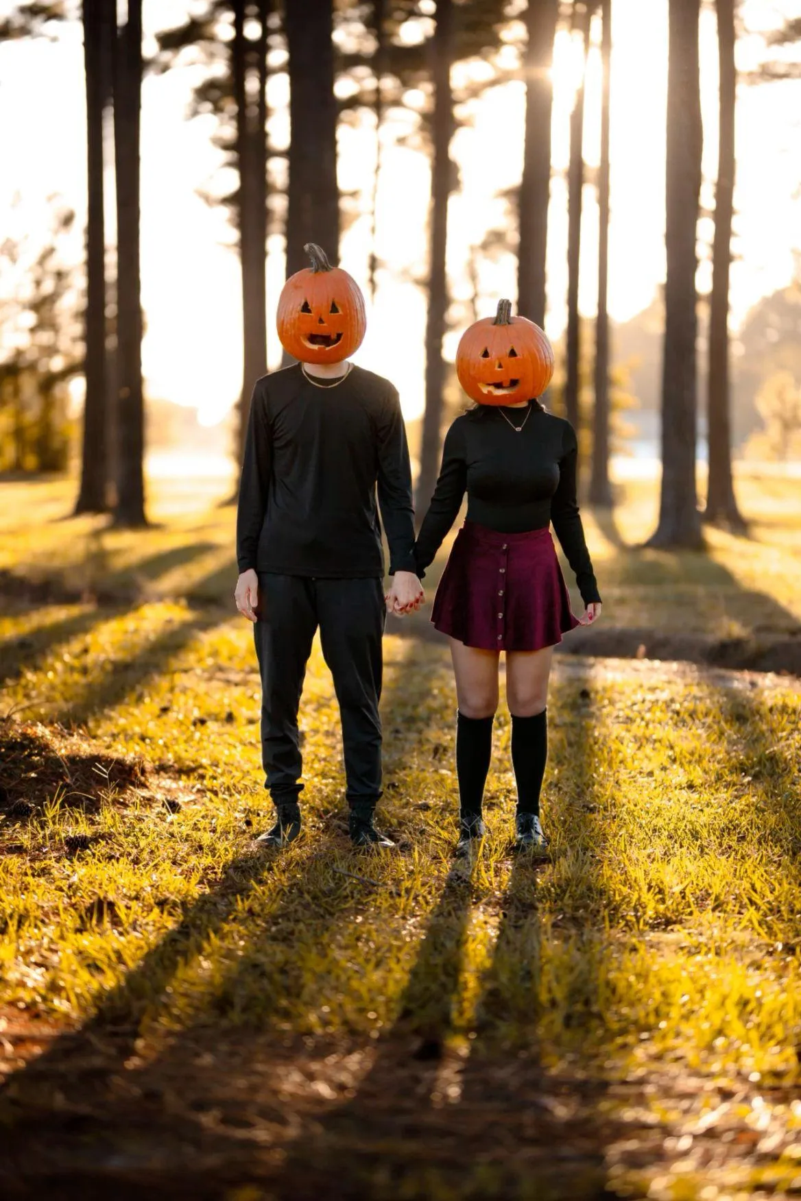 Couple Wearing Pumpkin Masks Walking Through Forest