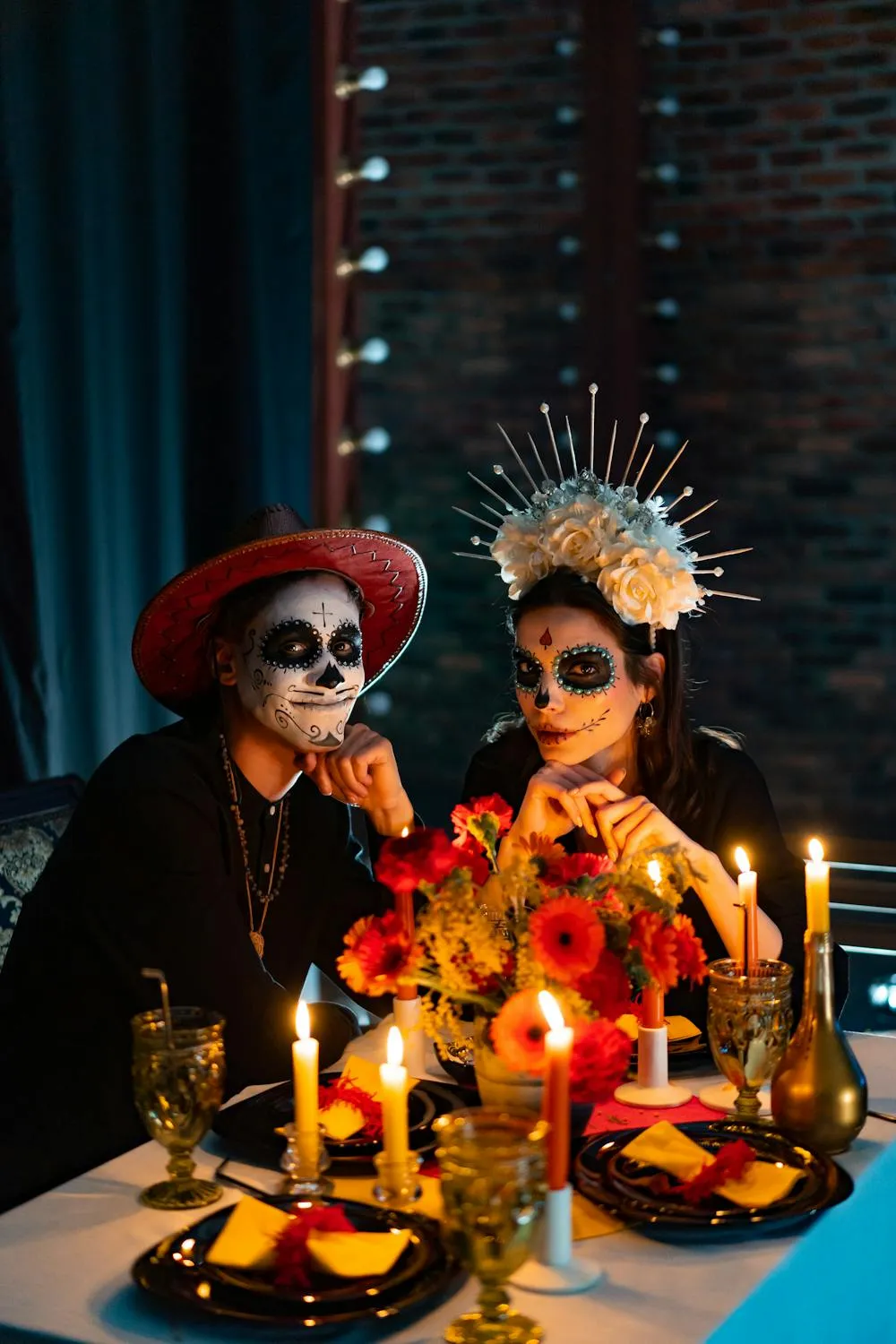 Couple with Day of the Dead Makeup Sitting at Candlelit Table
