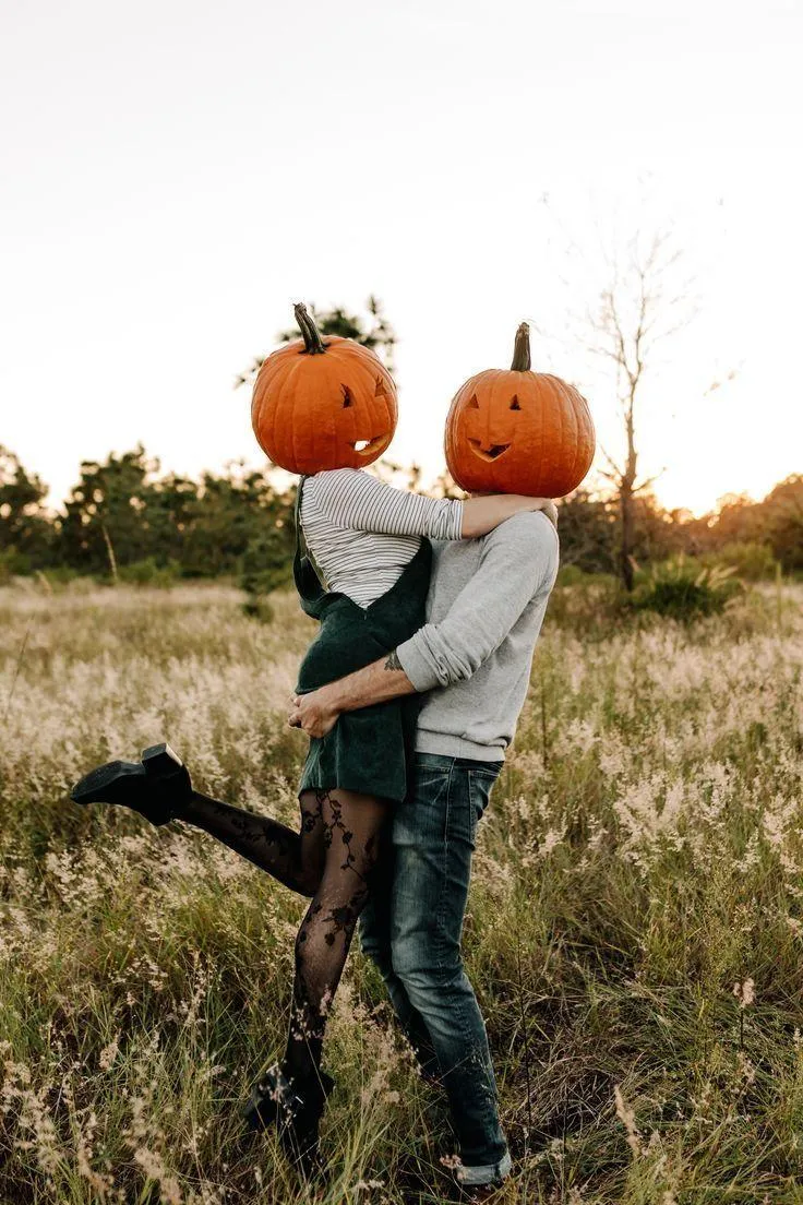 Couple with Pumpkin Heads in Field Embracing HD image