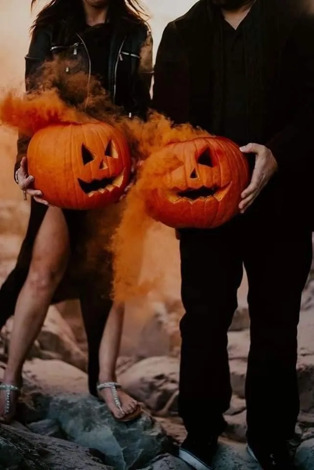 Couple with pumpkin heads posing at Halloween festival