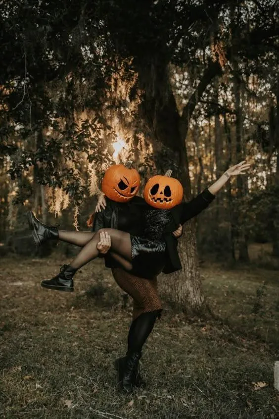 Couple with pumpkin heads sharing a playful Halloween moment