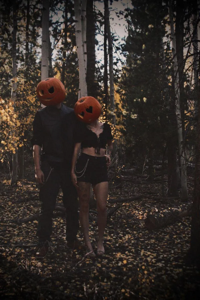 Couple with Pumpkin Heads Standing in Forest HD image
