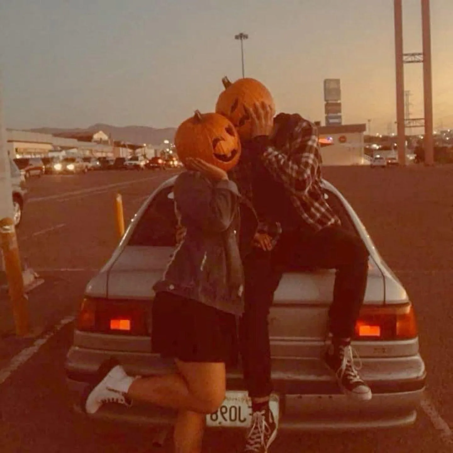 Couple with Pumpkins on Car at Halloween Festival Wallpaper