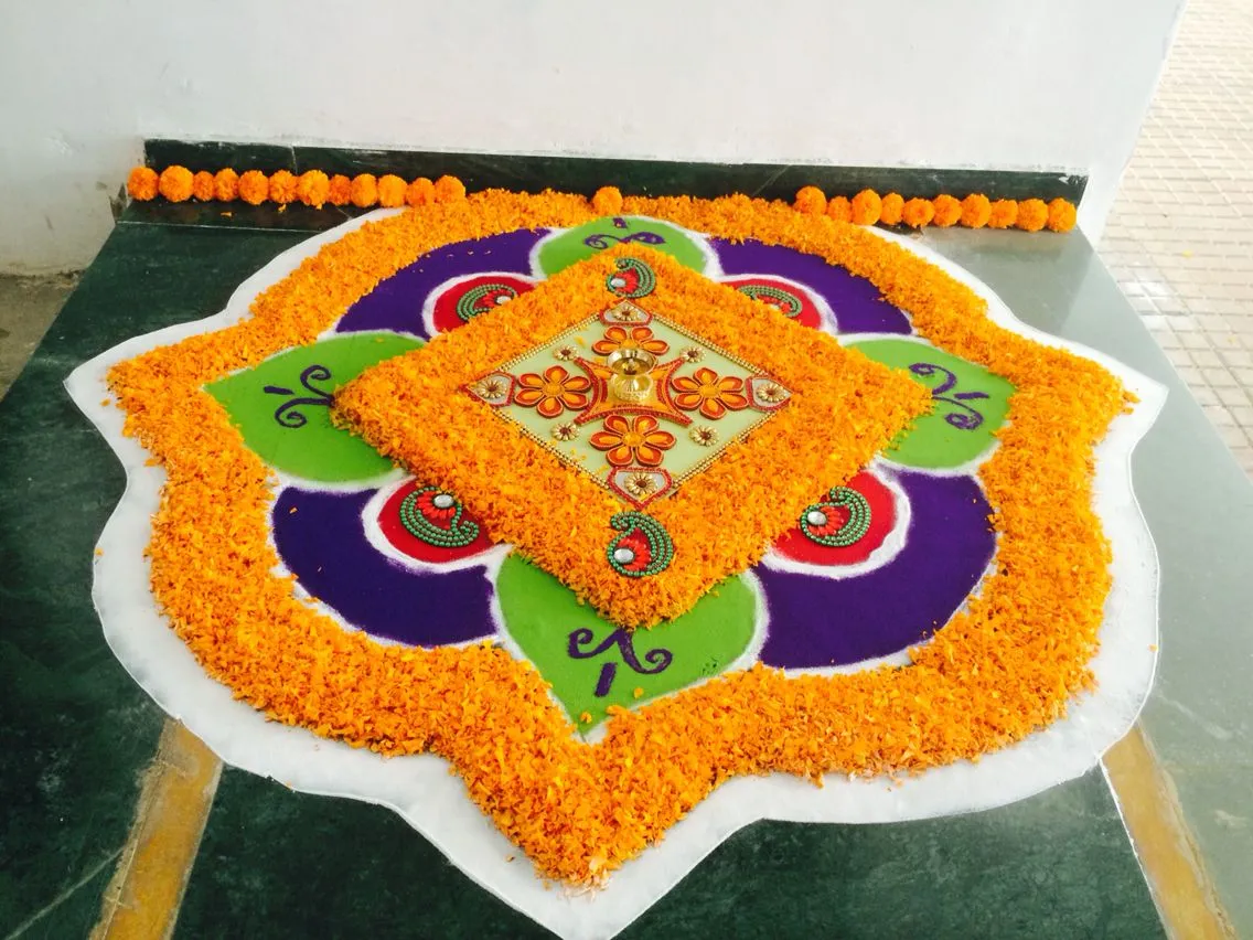Creative Onam pookolam with orange marigolds and rangoli art