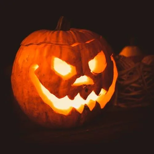 Creepy Jack O Lantern Pumpkin Glowing with Dark Background
