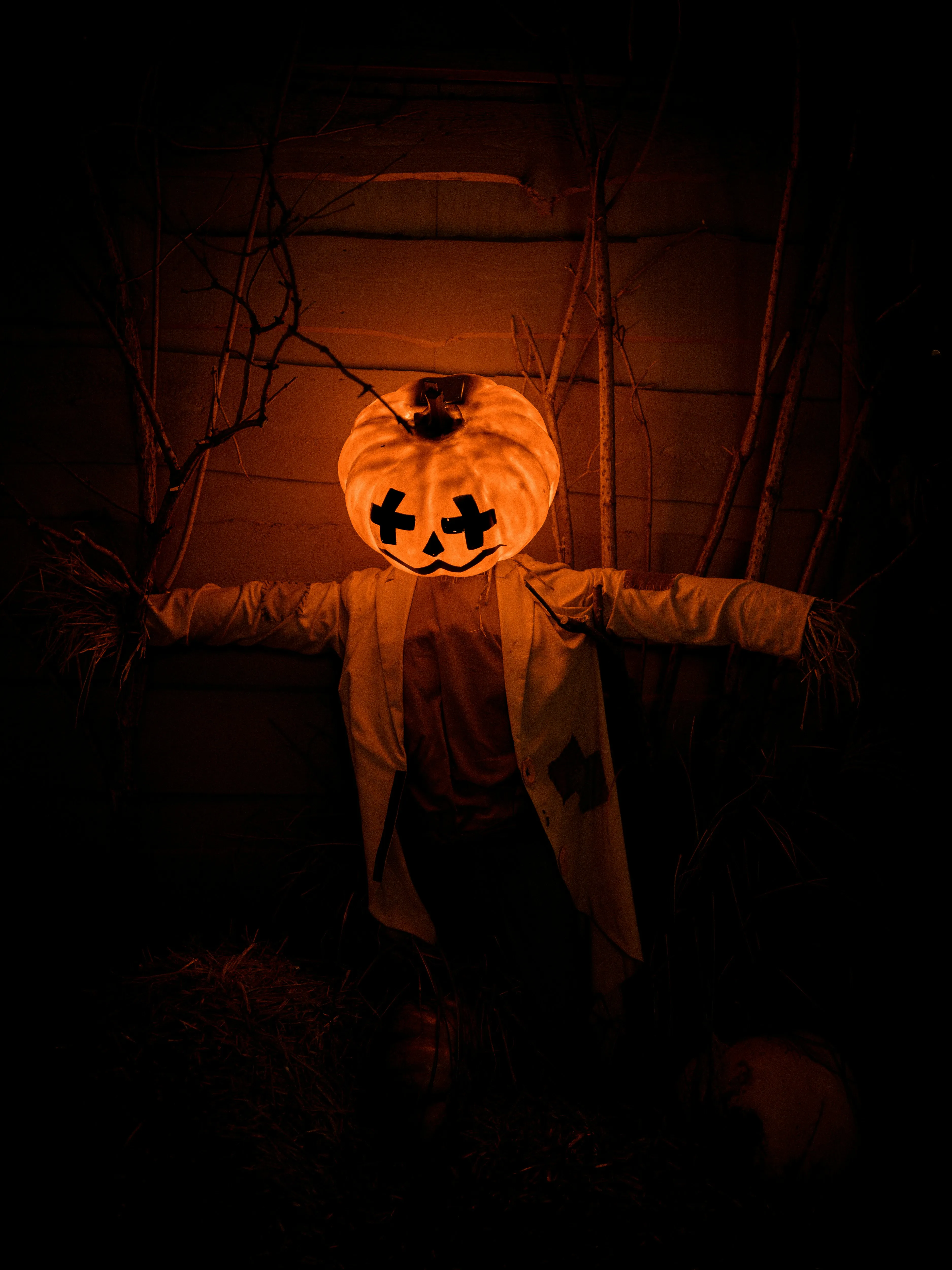 Creepy Pumpkin Head on Scarecrow in Dark Hallway Wallpaper