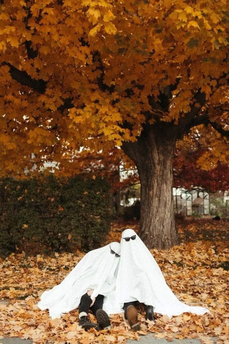 Cute Ghost Couple in Autumn Leaves Under Golden Tree