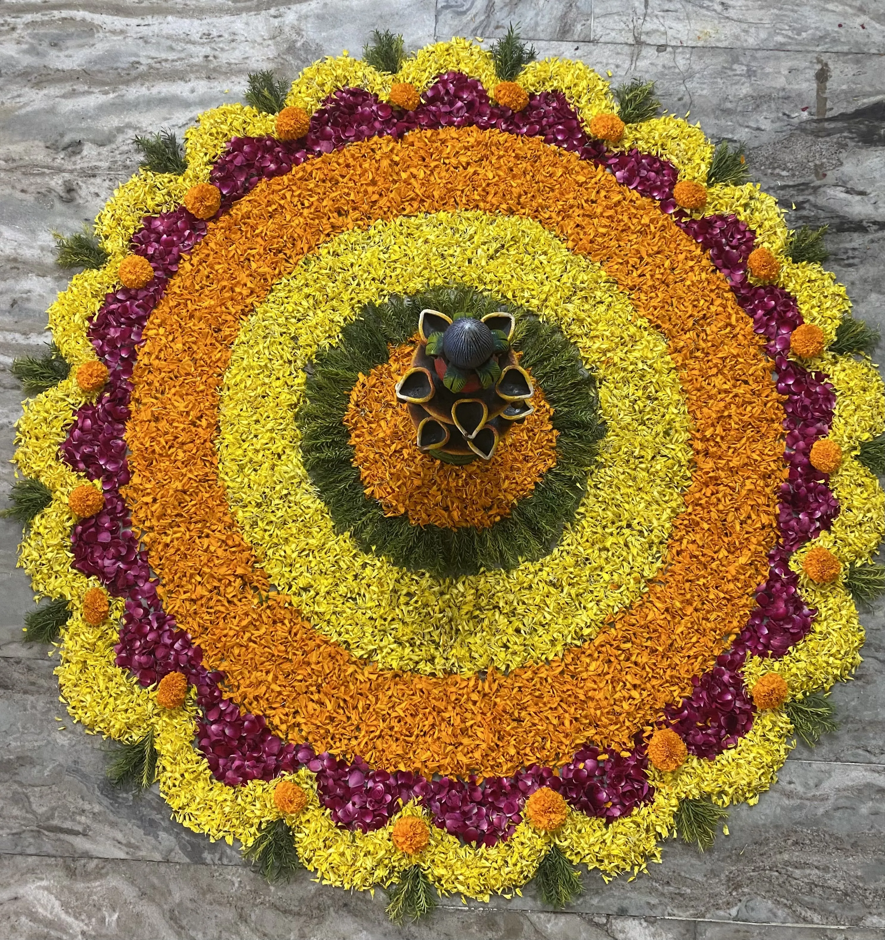 Elegant floral Onam rangoli with yellow and orange flowers