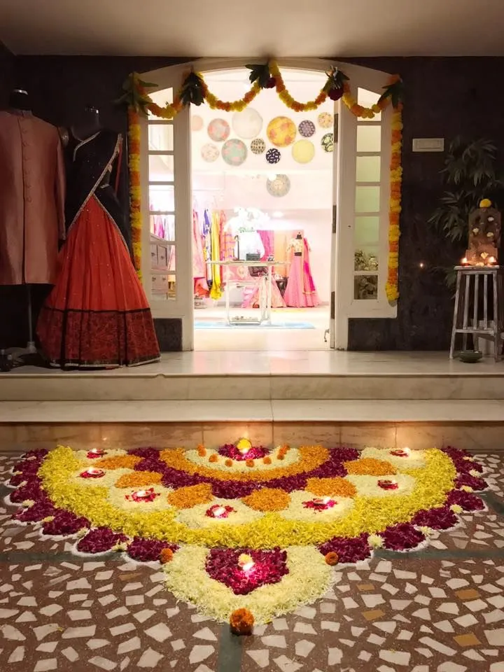 Elegant Onam flower rangoli design at the shop entrance