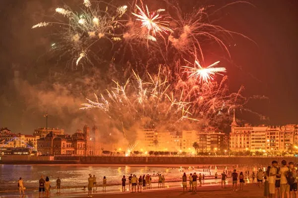 Evening fireworks display over city beach by professional team