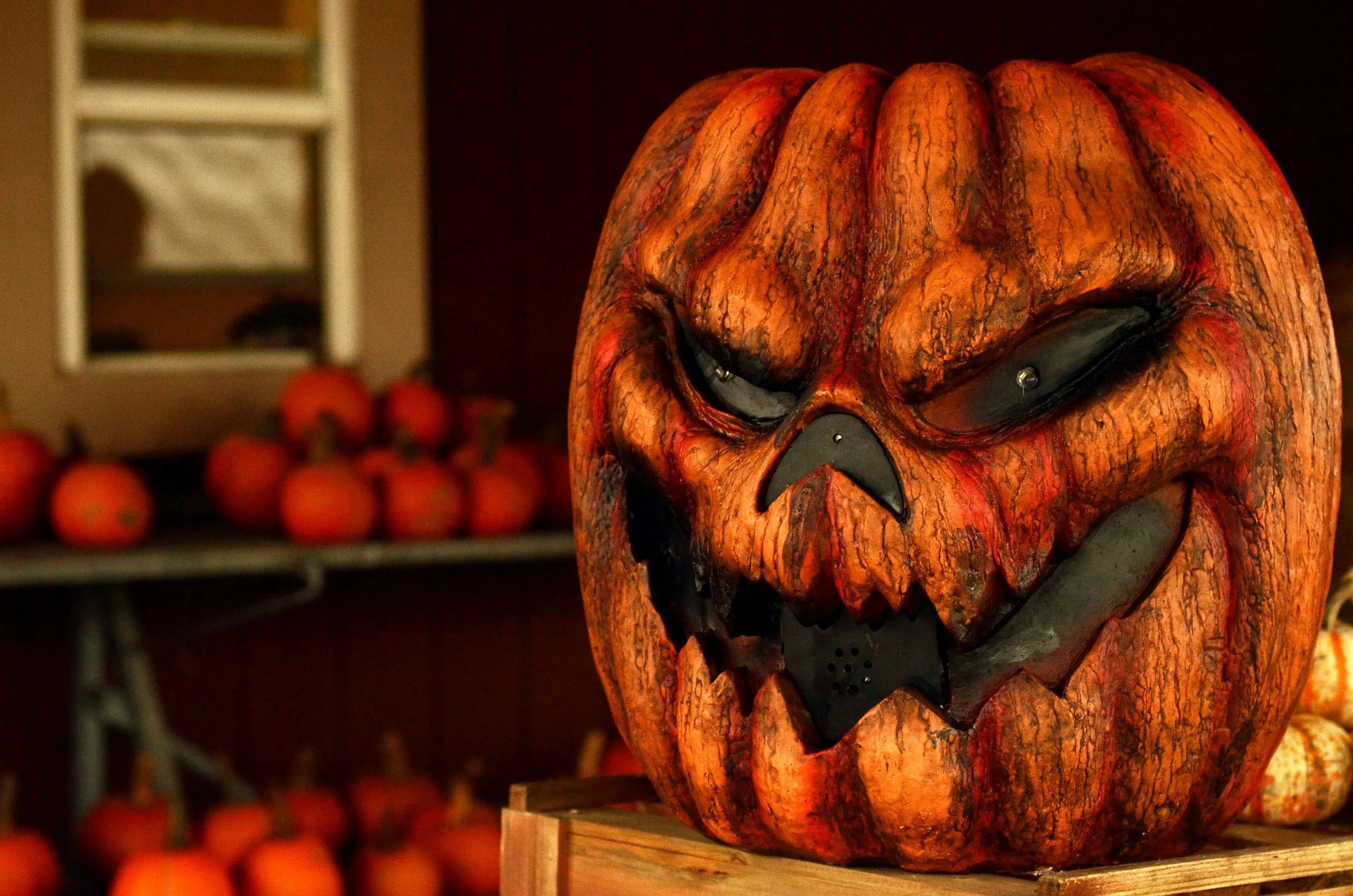 Evil Carved Pumpkin Face Glowing on Table Wallpaper