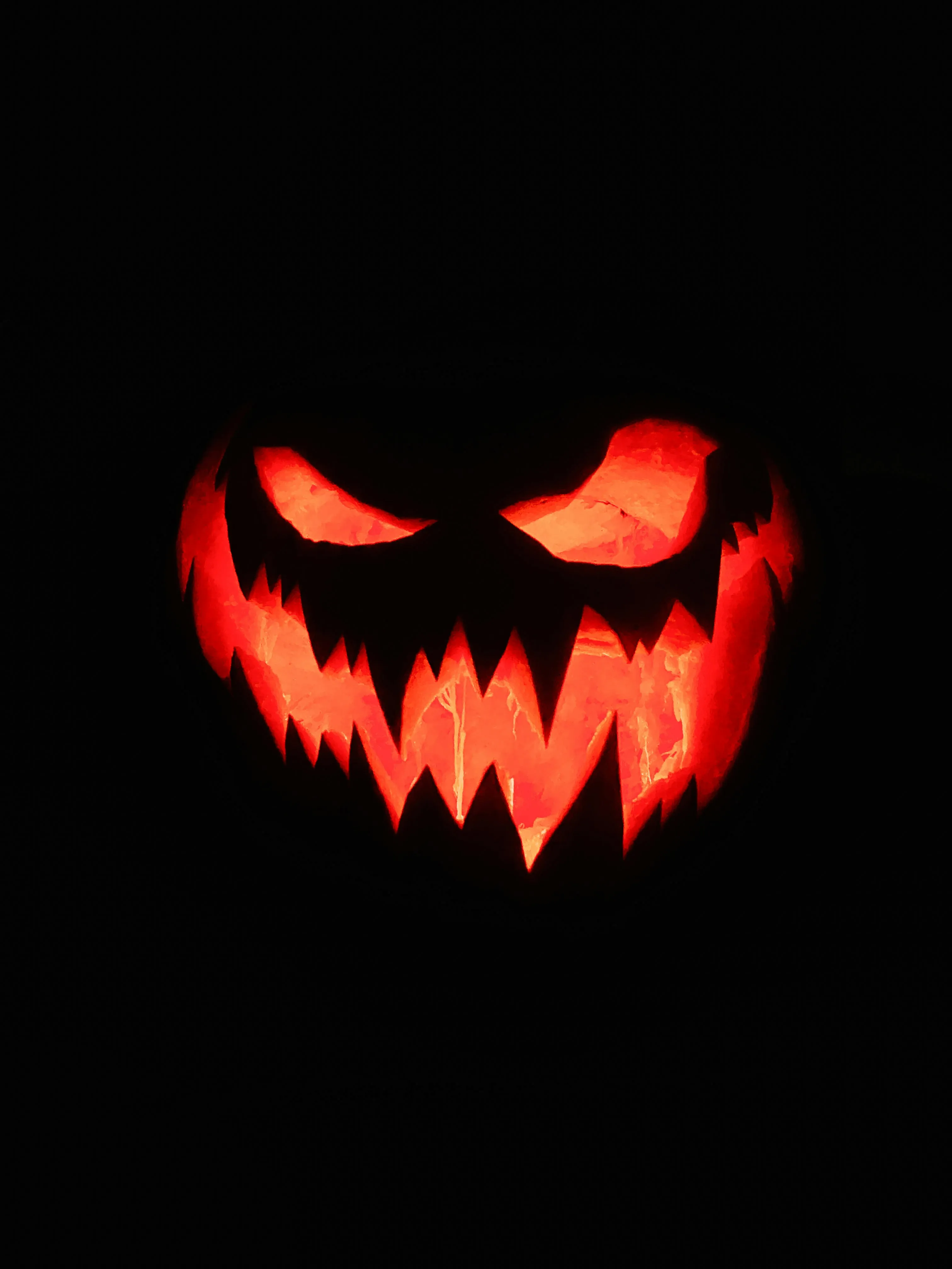Evil Glowing Pumpkin Face on Black Background For Halloween
