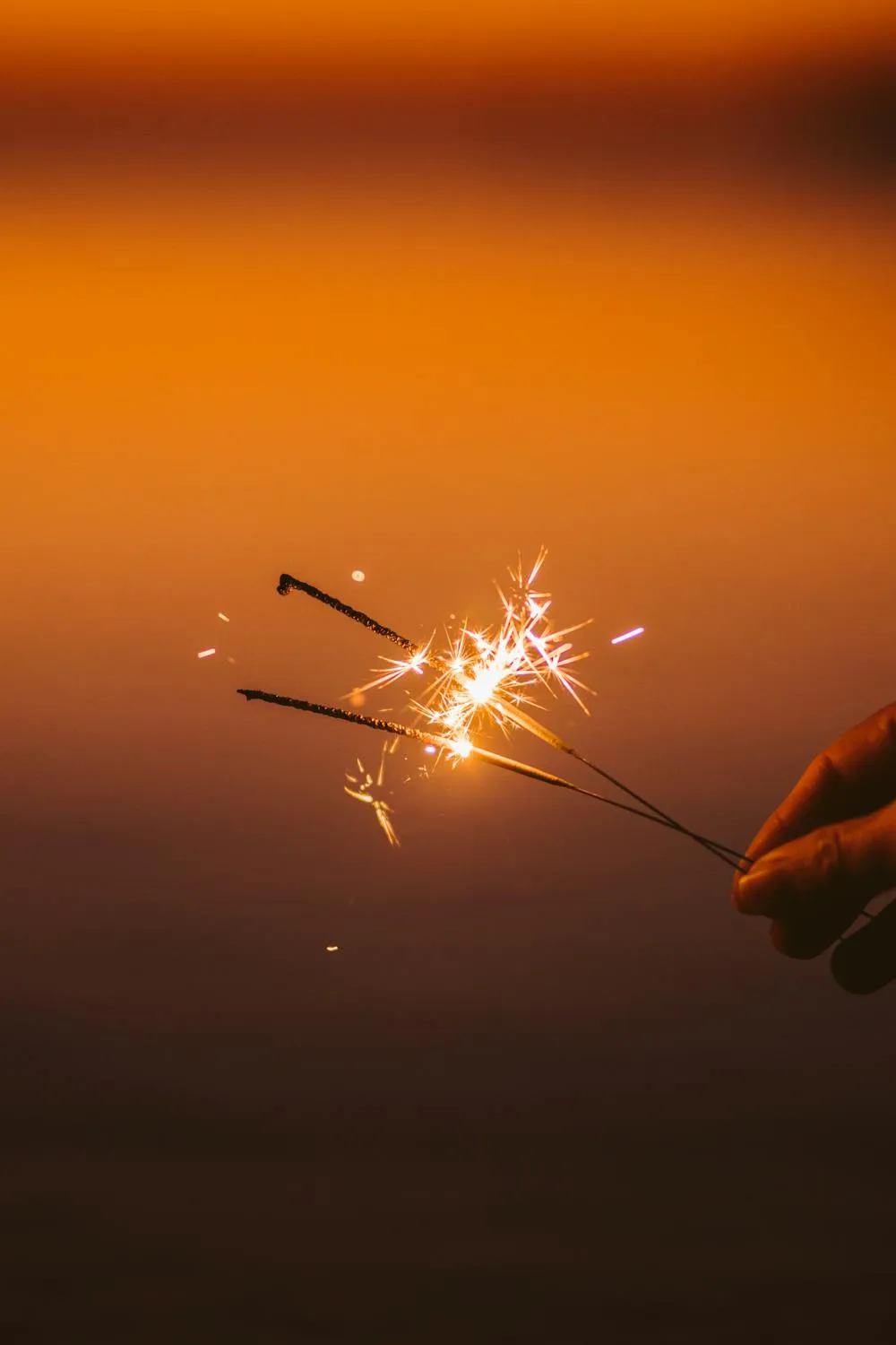 Expert capture of a hand holding sparklers during sunset