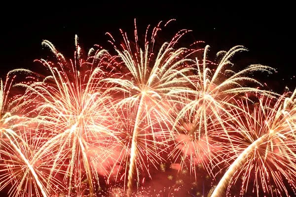 Explosive red and orange fireworks lighting up the sky