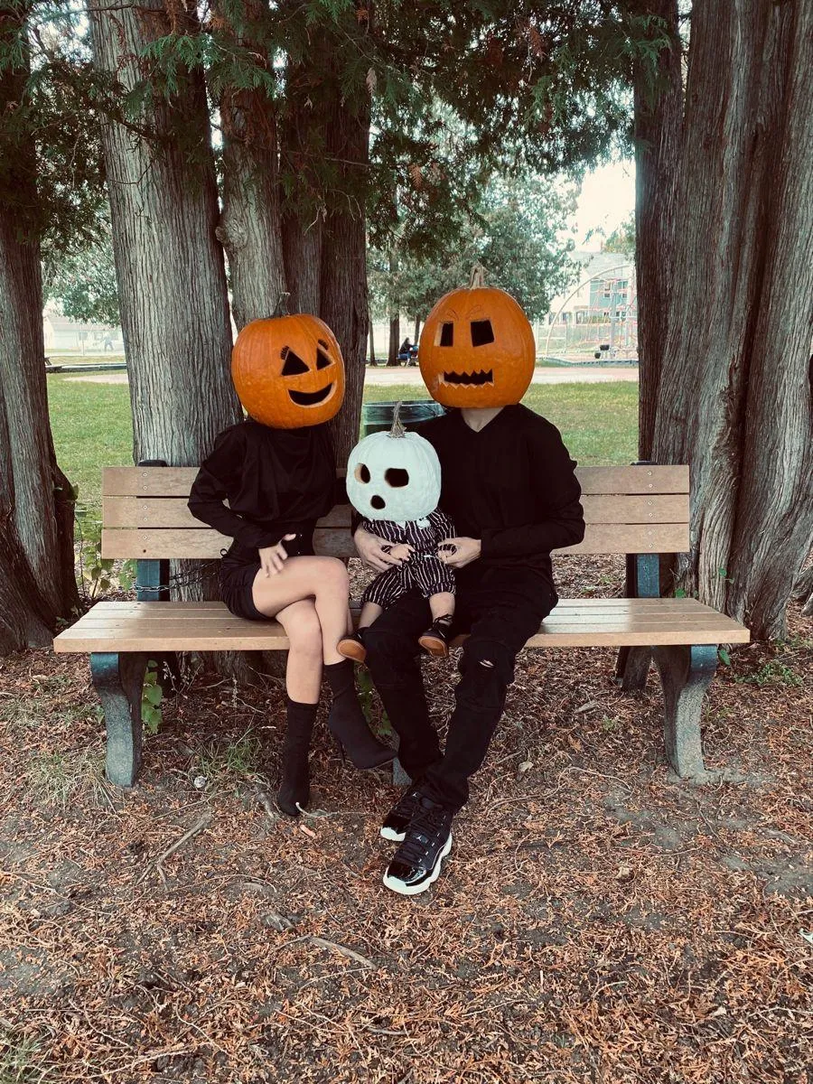 Family in Mixed Costumes Relaxing on Bench in Park