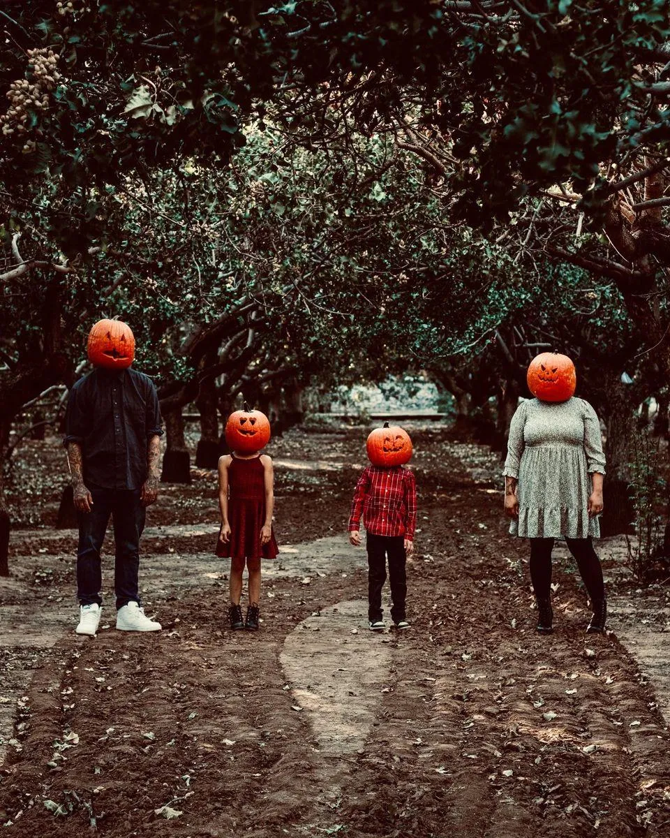 Family in Pumpkin Masks Standing in Forest HD Wallpaper
