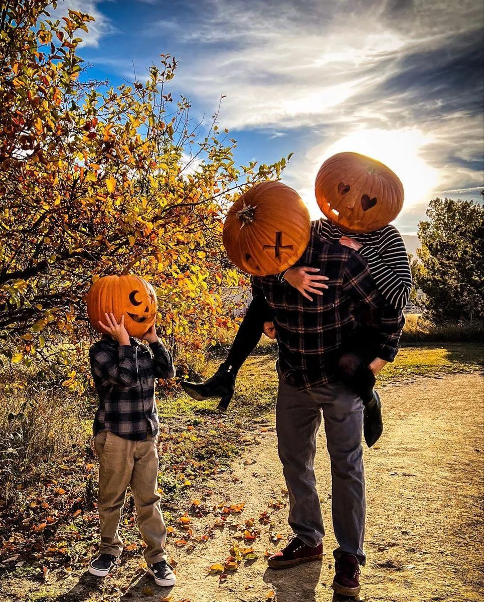 Family of Pumpkin Heads Walking Under Bright Autumn Sky