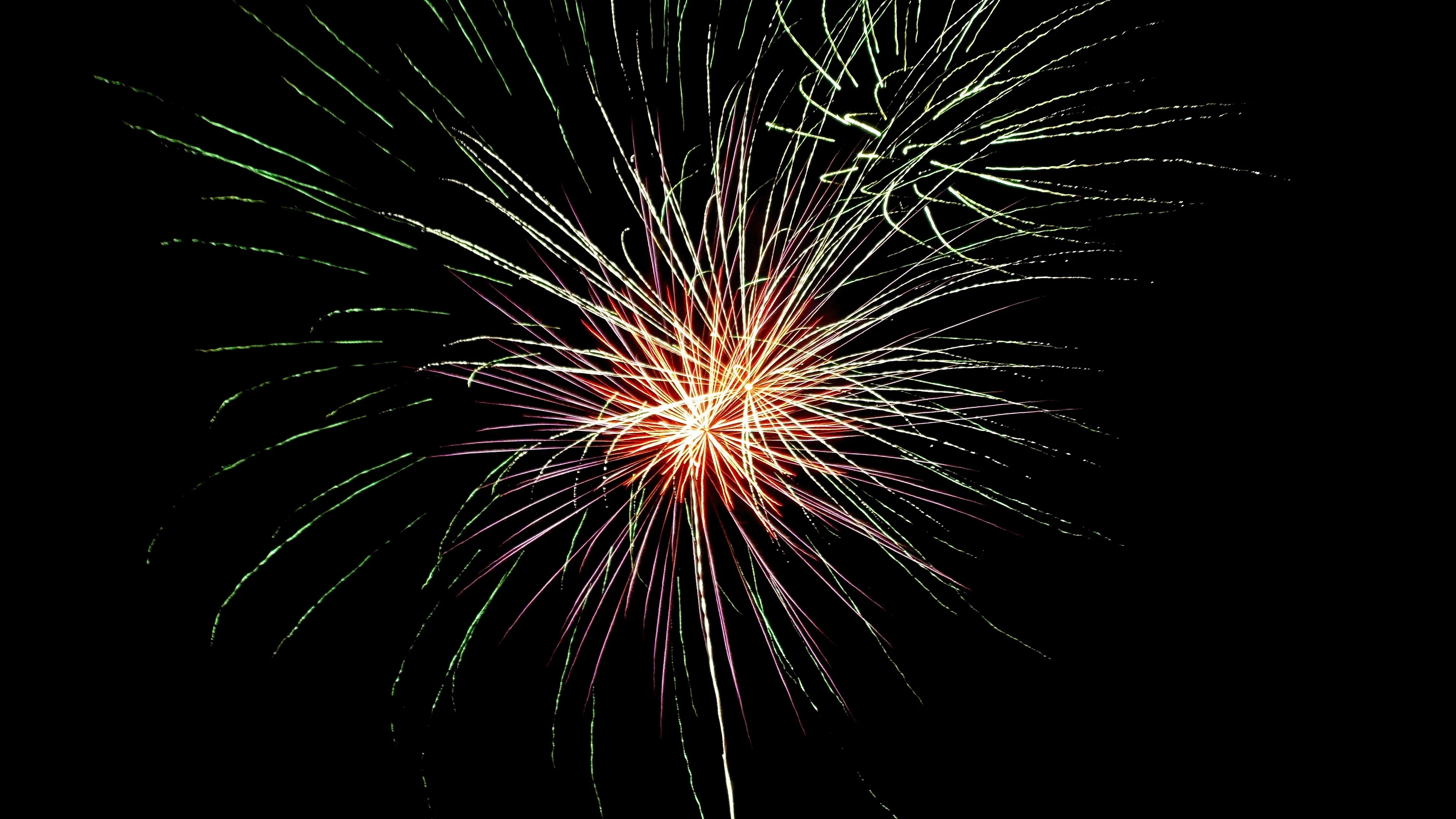 Fiery Green and Red Fireworks Illuminating Dark Night