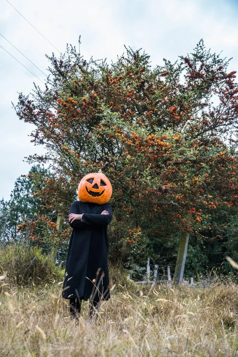 Figure with Pumpkin Head in Forest during Halloween Festival
