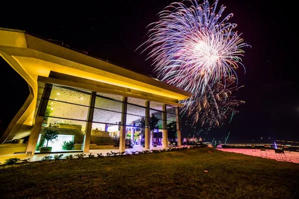 Fireworks Bursting Behind a Modern Building at Night