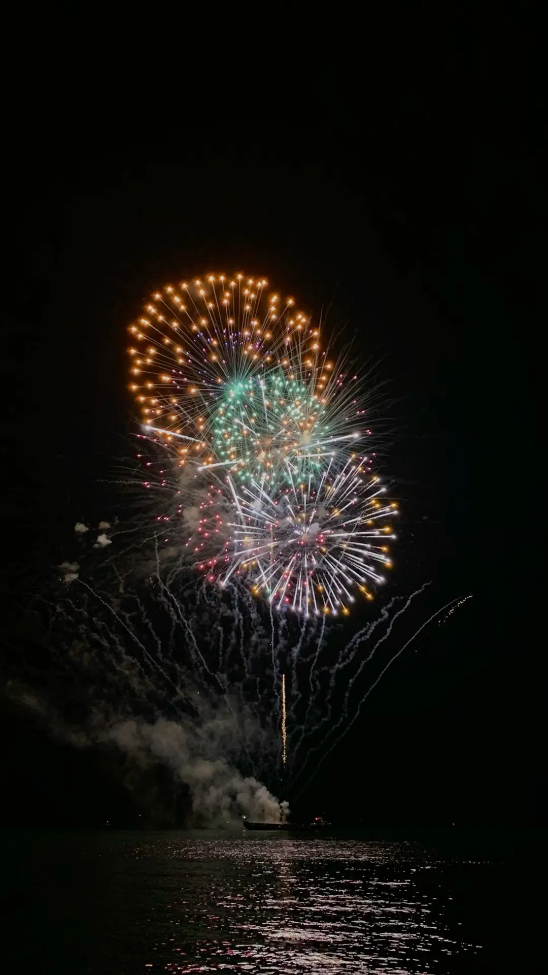 Fireworks bursting in orange and blue with dark sky