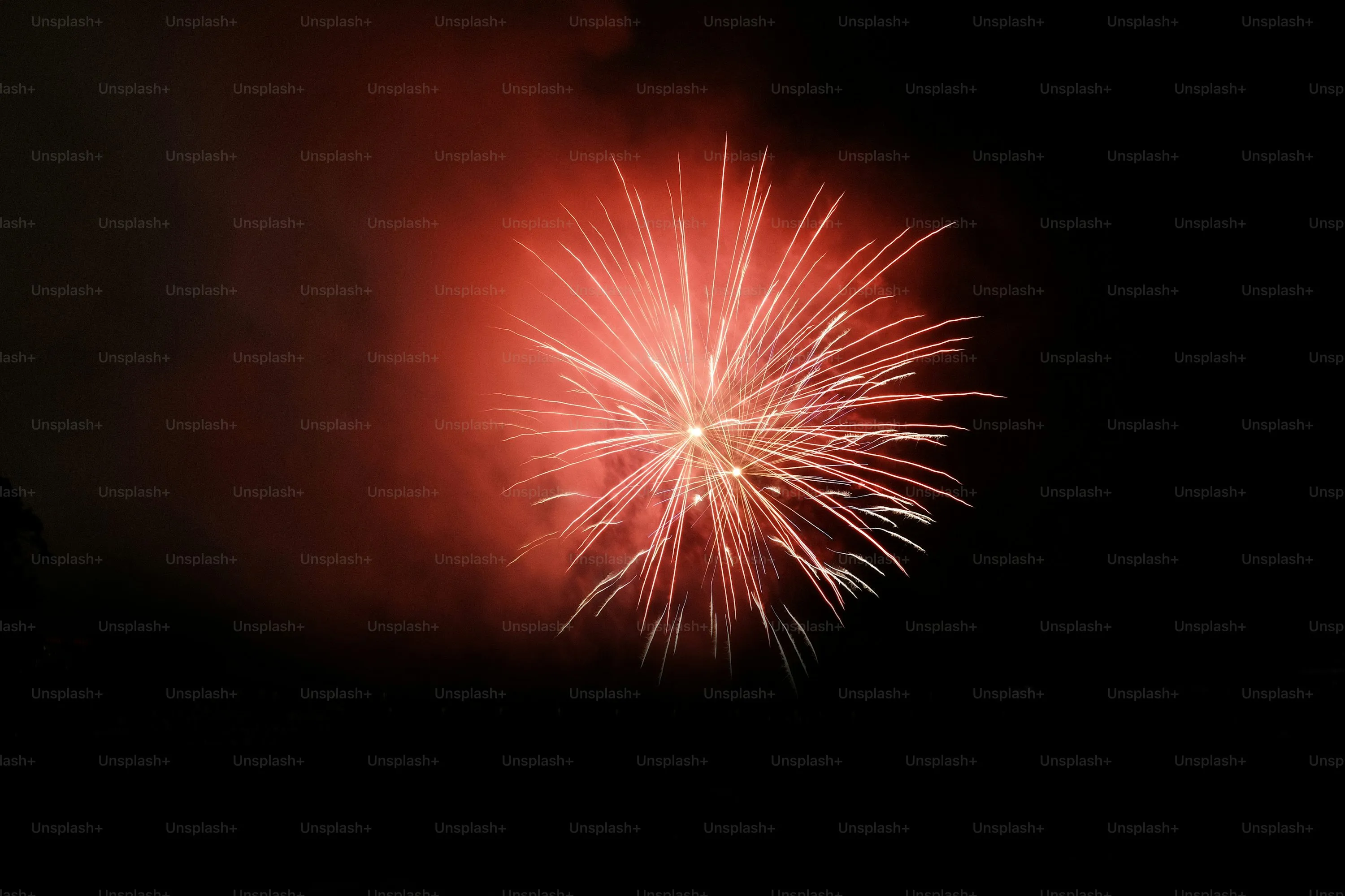 Fireworks Bursting in Red and Yellow Lights over a City
